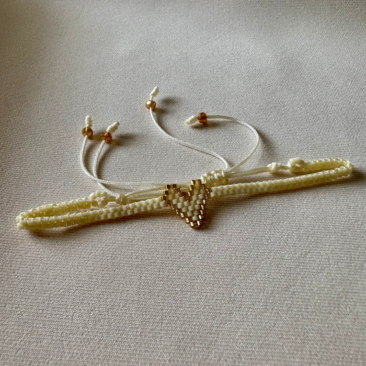 PULSERA CORAZÓN BEIGE CON FILO DORADO