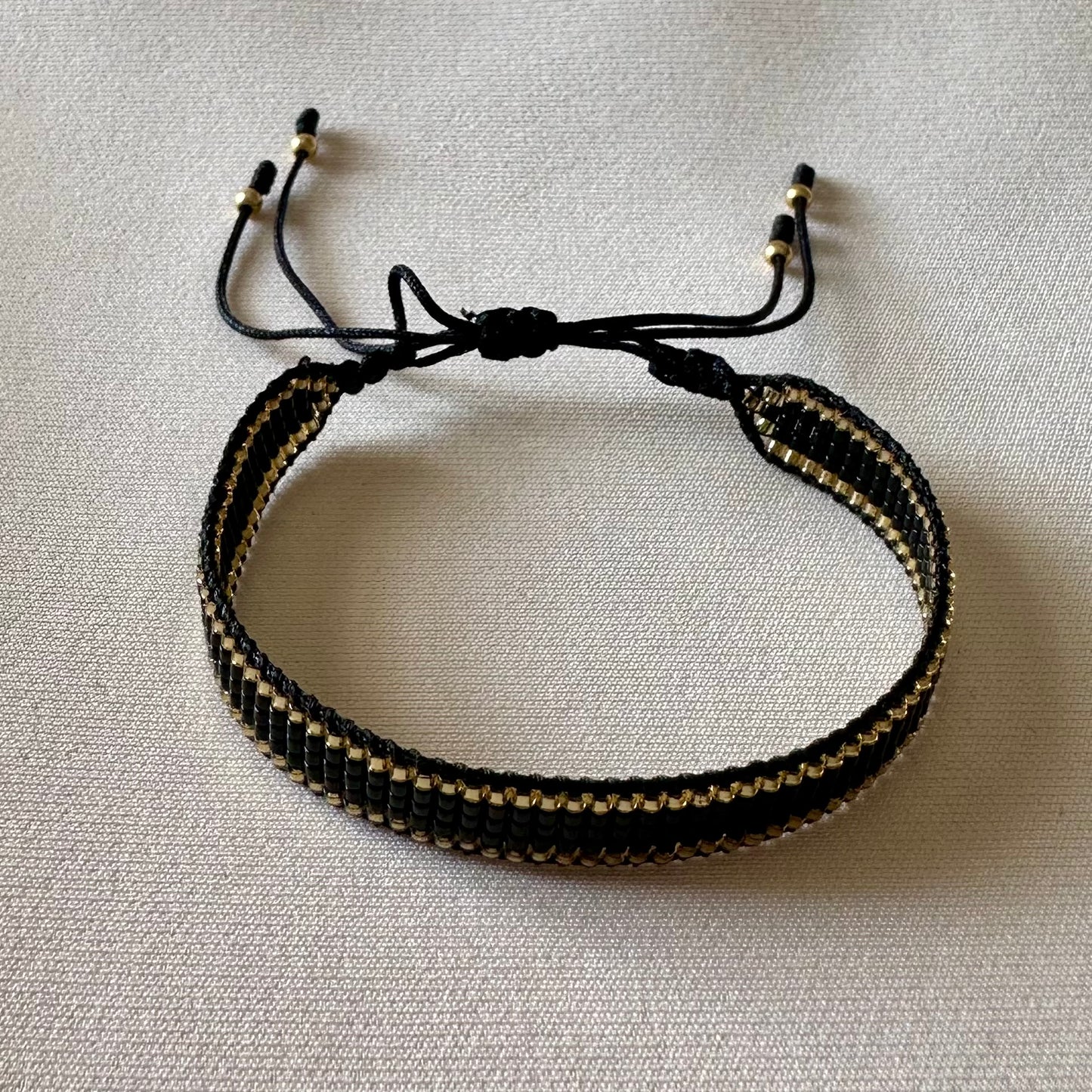 PULSERA NEGRA CON DORADO