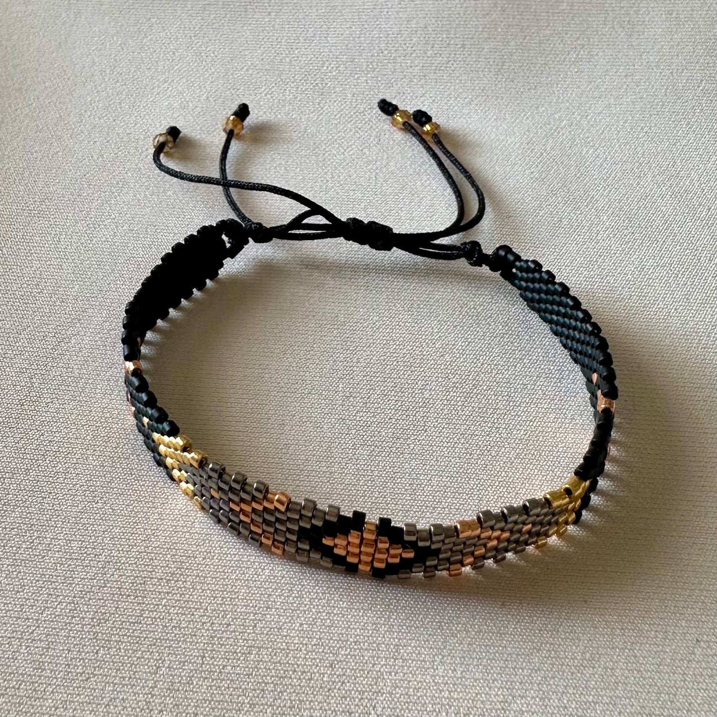 PULSERA NEGRO, PLOMO, DORADO Y COBRE